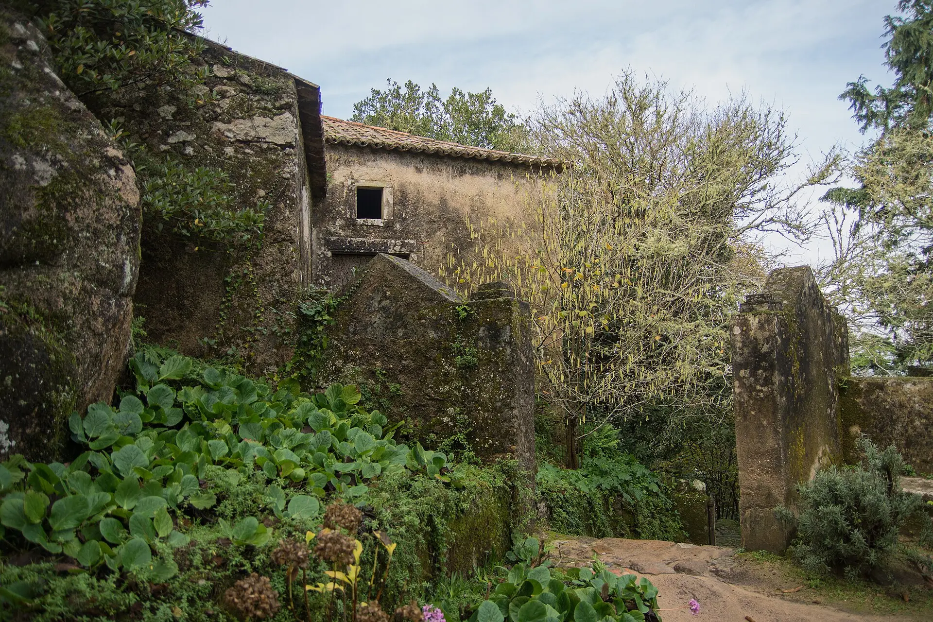 Moss-covered stone buildings of the Capuchos Convent in the forest