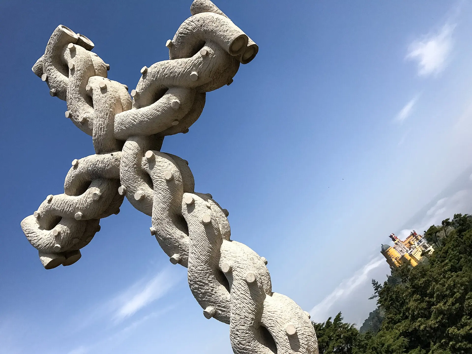 The carved stone cross at Cruz Alta, with Pena Palace in the distance